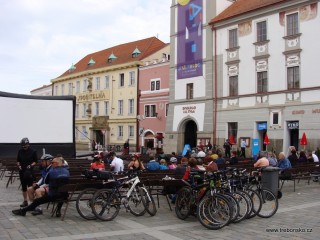 Lavičky na Masarykově náměstí obsazené přes den turisty a cykloturisty, večer malými i velkými filmovými diváky